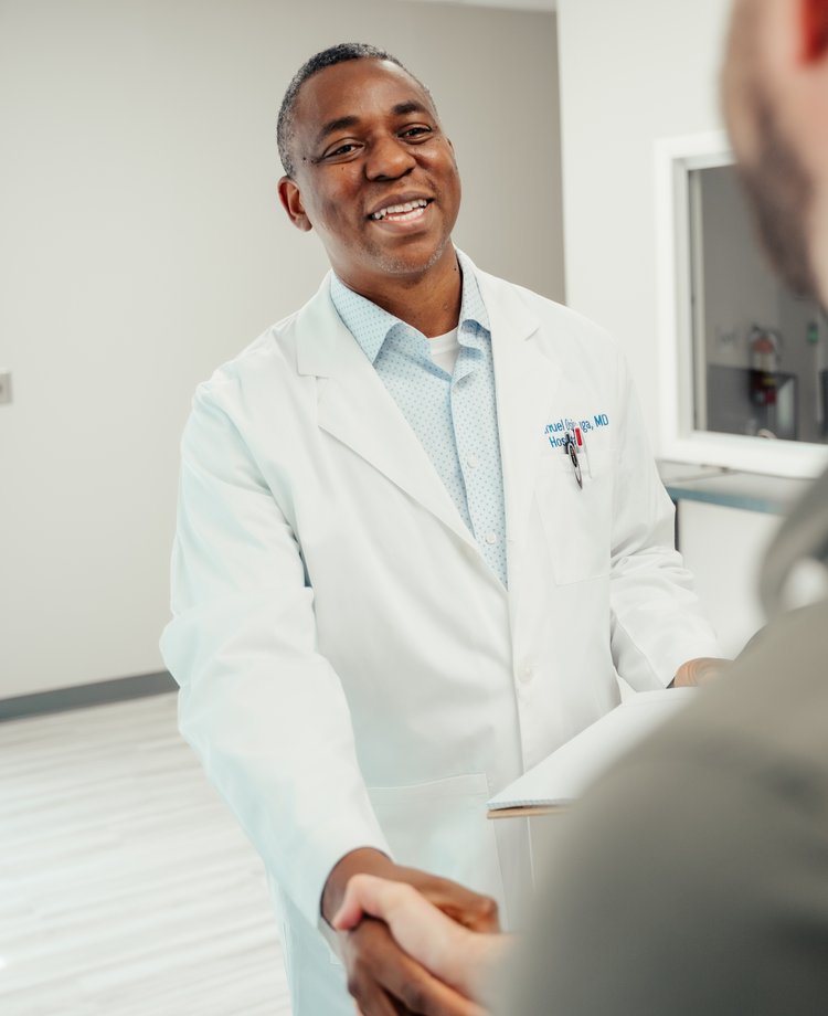 Dr. Emmanuel Osinuga shaking hands with a patient at Pivot Health & Lifestyle